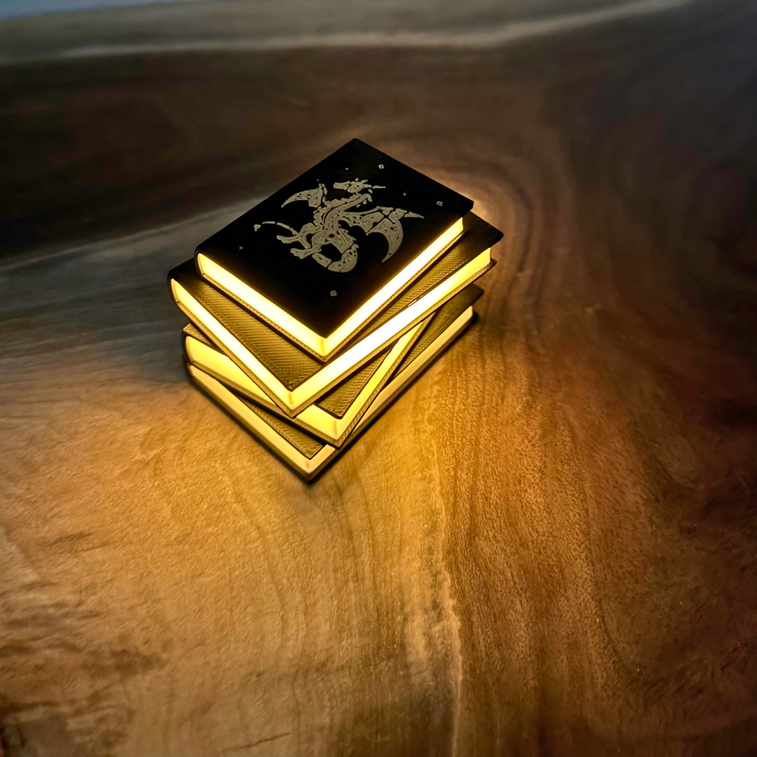 Stack of glowing books with a dragon emblem on a wooden surface
